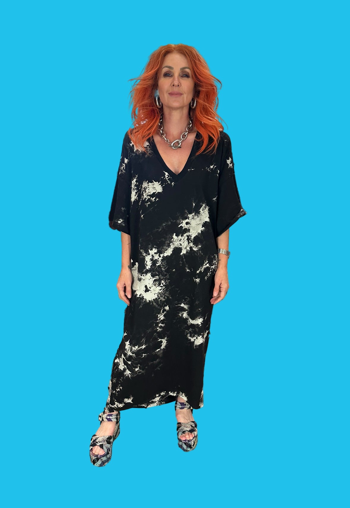 Woman wearing a black and white tie-dye dress against a blue background