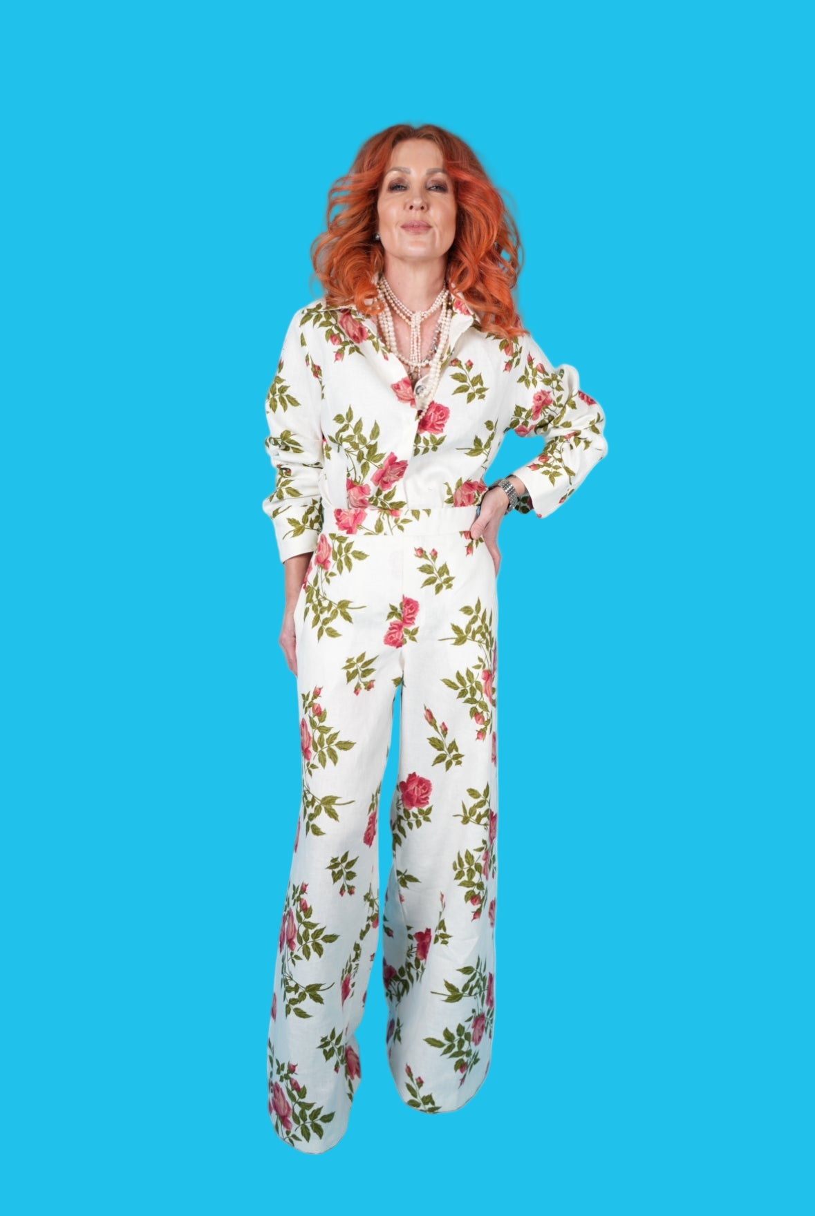 Person wearing a floral jumpsuit on a blue background